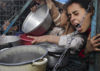 Pessoas esperam para receber alimentos no campo de refugiados de Jabalia, Faixa de Gaza, Palestina, em 18 de março de 2024.