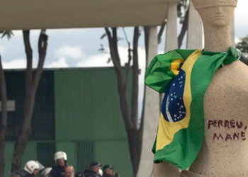 Débora Rodrigues, que pichou a estátua da Justiça, cumprirá pena em casa com tornozeleira eletrônica. Entenda o caso que pode resultar em 14 anos de prisão.