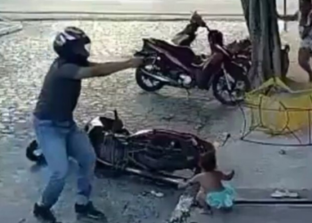 Cena chocante mostra menina brincando na calçada durante ataque a tiros; pai da criança foi baleado três vezes na perna, mas já recebeu alta hospitalar.