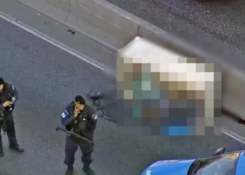 Corpo de homem é encontrado dentro de caixote na Avenida Brasil, em Bonsucesso, Rio de Janeiro. Polícia investiga as circunstâncias da morte; vítima ainda não identificada.