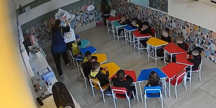Vídeo flagra professora agredindo aluno de 4 anos com livros em escola de Caxias do Sul. Criança teve seis dentes afetados e polícia investiga o caso.