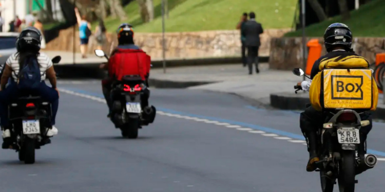 Banco Central indica que aplicativos de transporte e entrega ajudaram a reduzir desemprego no Brasil. Porém, estudos apontam precarização, com renda menor e jornadas mais longas para motoristas e entregadores.