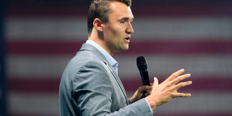 Uma imagem de Charlie Kirk discursando em um evento, representando sua atuação como ativista político.