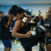 A psicanalista Ana Paula Lino superou o trauma da violência doméstica e hoje oferece aulas de Muay Thai para mulheres no projeto Menina-Moça Mulher, no centro do Rio, promovendo empoderamento e autodefesa.