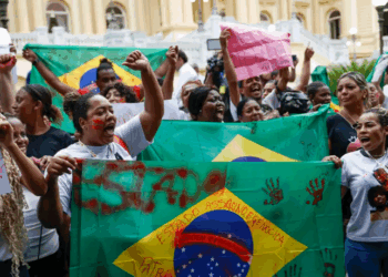 Moradores do Alemão e da Penha protestam no Palácio Guanabara contra o governador Cláudio Castro, após operação policial deixar mais de 100 mortos. Manifestantes acusam o governo de genocídio e uso político da violência nas favelas do Rio.