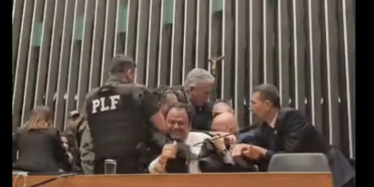 Deputado Glauber Braga é retirado à força da cadeira da presidência da Câmara após protesto contra votação de sua cassação. Sessão tem interrupção da TV Câmara e provoca reação de parlamentares.