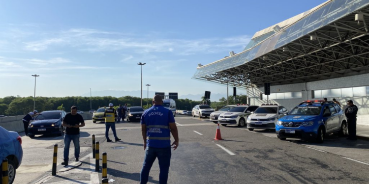 Motorista é preso por uso de documento falso durante operação no Galeão e Santos Dumont. Fiscalização também interditou veículos irregulares e autuou concessionária.