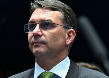 Flávio Bolsonaro relaciona urnas brasileiras à Smartmatic durante encontro com diplomatas, mas TSE contesta a informação.