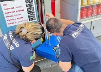 Agentes fiscalizam bomba de combustível durante ação de controle em posto no estado do Rio.