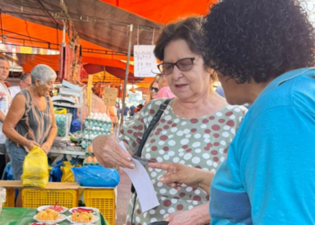 Comlurb realiza campanha sobre coleta seletiva em feira livre de Santa Cruz, na Zona Oeste do Rio, e orienta moradores sobre reciclagem.