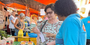 Comlurb realiza campanha sobre coleta seletiva em feira livre de Santa Cruz, na Zona Oeste do Rio, e orienta moradores sobre reciclagem.