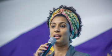  Manifestantes em ato de apoio a Flávio Bolsonaro fizeram comentários ofensivos sobre Marielle Franco perto da PUC-Rio. Familiares criticaram o episódio.